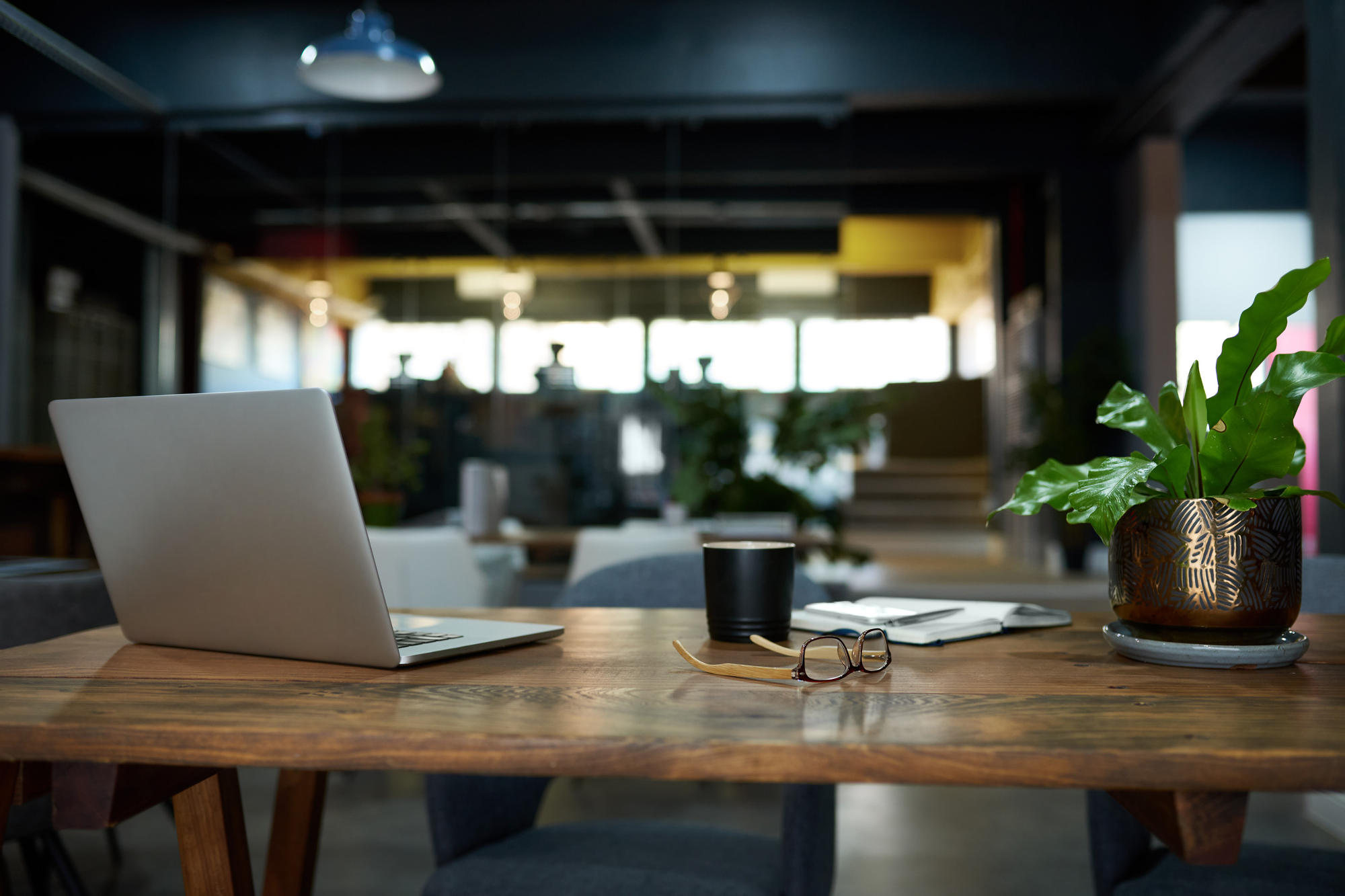 Items sitting on wooden desk in an office, against blurred background