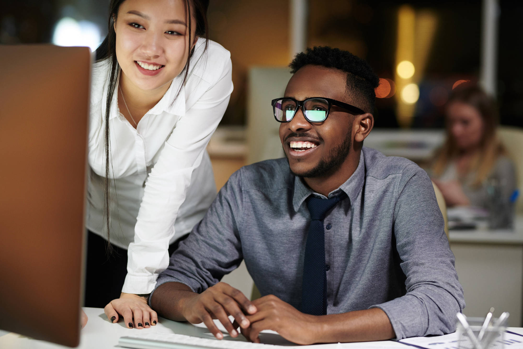 Smiling work colleagues working late in an office